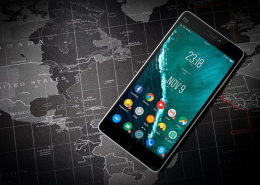 Smartphone with Android-Icons on the start screen in front of a world map